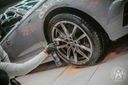Wheel Cleaner Bleeding – Action shot rinsing alloy wheel of grey car with water hose, brake dust and cleaner running off | Car Detailing | miio Store