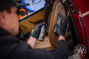 Leather Quick Detailer – Detailer com luvas pretas a aplicar produto no painel de couro de carro clássico vermelho | Cuidado do Couro | miio Store