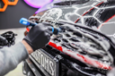 Shampoo No Scent 1L – Close-up de mão com luva a fazer espuma em carroçaria vermelha escura no estúdio JK Customs | Lavagem Auto | miio Store