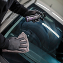 EZ Wiper – Mão com luva a usar pano cinza de microfibra para aplicar selante em janela lateral do carro para proteção hidrofóbica | Vidros Auto | miio Store