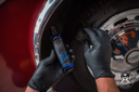 Tyre Dressing 500ml – Main gantée appliquant produit sur flanc pneu voiture classique, carrosserie vintage rouge foncé visible | Detailing Auto | miio Store