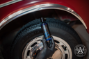 Tyre Dressing 500ml – Flacon appuyé contre pneu et jante chromée voiture classique montrant positionnement après traitement | Detailing Auto | miio Store